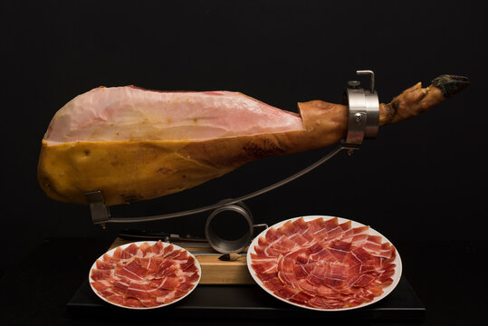 Jam&oacute;n sobre jamonero preparandolo para limpieza y corte con emplatado.