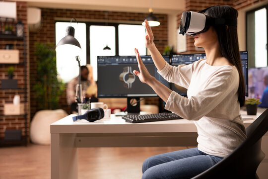 Young woman with vr headset working on clamp model in CAD software at home studio. Freelance female engineer exploring virtual reality environment for accurate 3D product prototyping and inspection.