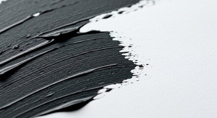 Opaque black paint strokes on white paper, textured and bold