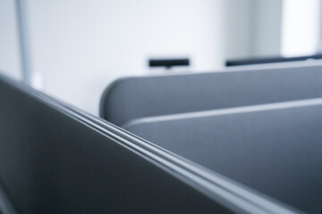 Close-up of grey partitions with a blurred chair, creating a minimalist composition.
