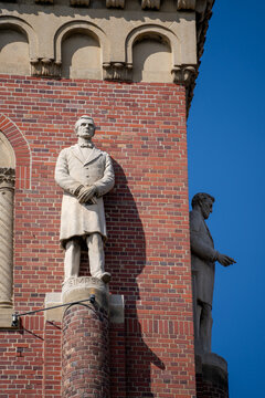Historic statue stands before brick university building