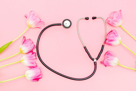 National doctors or nurse day with stethoscope,bunch of tulips flowers.Health medicine Day.Copy space for text.mockup greeting card on pink background