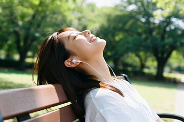 Woman enjoying music in a park with eyes closed