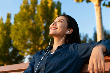 Young woman enjoying music outdoors in a peaceful park