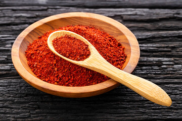 Crushed annatto seeds in the spoon and in the bowl - Bixa Orellana