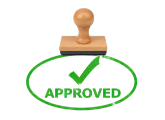 Wooden rubber stamp with a green ink impression of a check mark and the word APPROVED within an oval shape on a transparent background signifying confirmation and validation