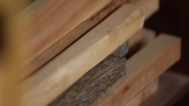 Vintage wooden letterpress blocks and tools stacked on a shelf in a workshop. Represents traditional printing, craftsmanship, typography, and history of media.
