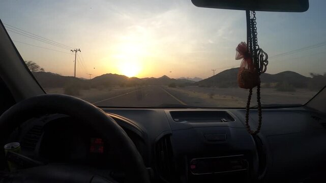 Cinematic POV drive through a desert highway at sunset, with a serene golden-hour atmosphere, viewed through the windshield, surrounded by a distant mountain range — perfect for travel vlogs or films.