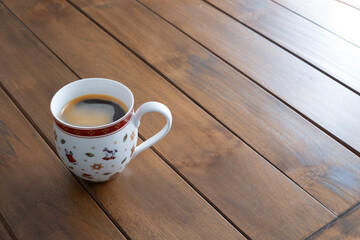 A festive Christmas mug filled with coffee on a wooden table, evoking warmth, comfort, and holiday spirit on a cozy winter morning, copy space