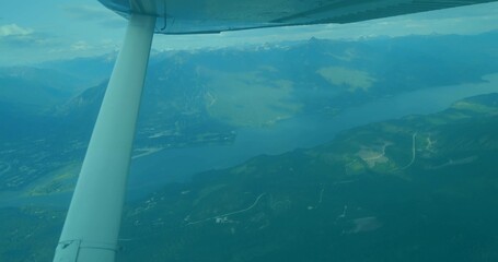 Showing white wing strut framing mountain valley from cabin window, with lake below, copy space