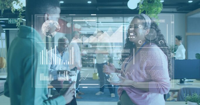 Woman in pink sweater holding coffee, discussing data on digital display panel in open plan office - Powered by Adobe