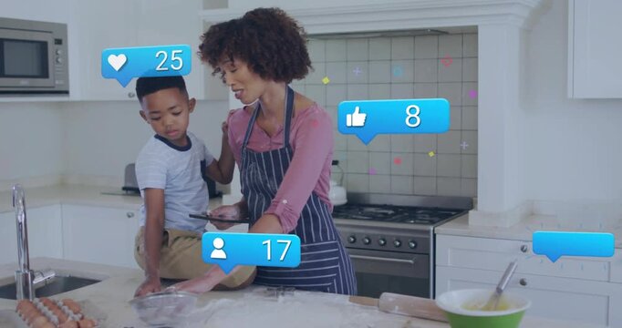 Mom tapping tablet while stirring flour with son as social icons floating showing cooking feedback
