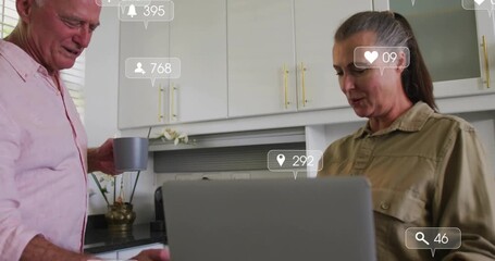 Mature woman opening laptop and scrolling causing social metrics climbing couple raising mugs - Powered by Adobe