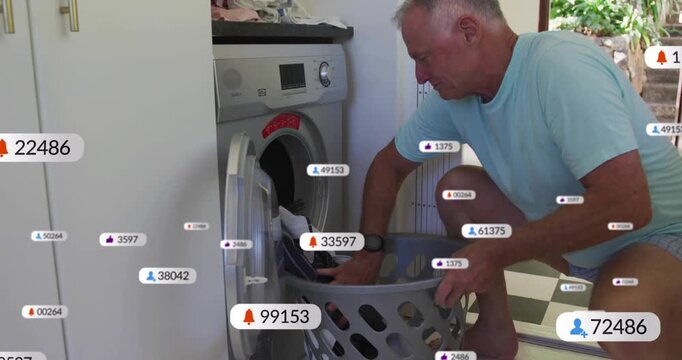 Senior man entering laundry room and loading clothes from basket into washing machine for washing