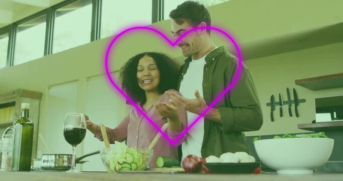 Woman tossing salad in kitchen initiating neon heart graphic around couple celebrating meal prep