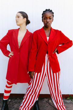 Women wearing red blazers and striped pants