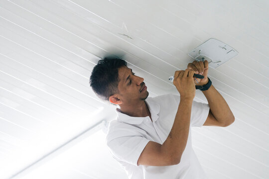Focused male technician installing security camera