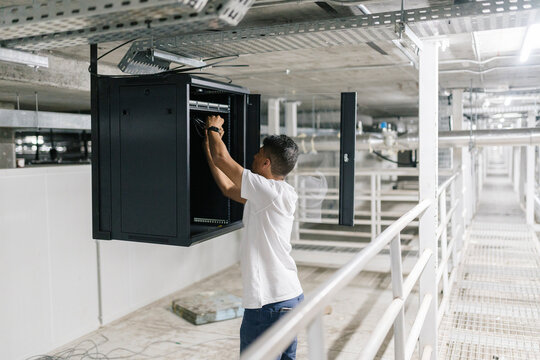IT engineer installing server in modern storehouse