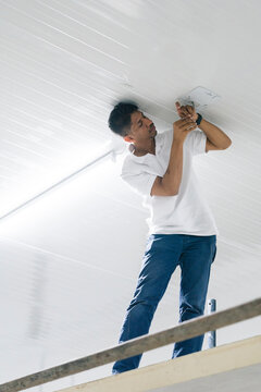 Focused man installing security camera communication