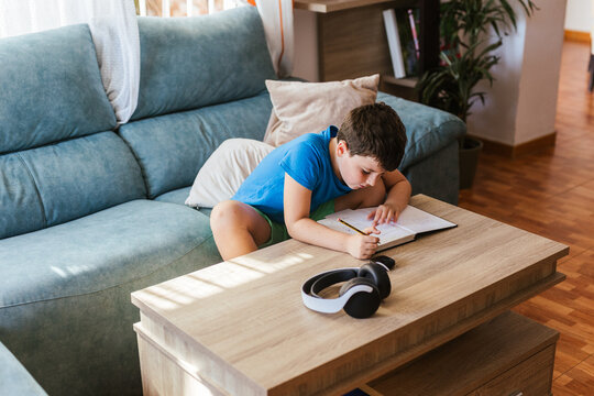 a child doing homework in the living room at home