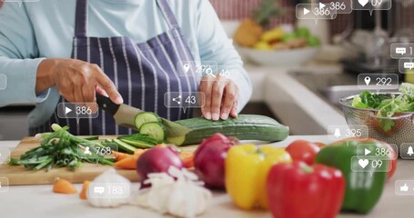 Placing cucumber, senior cook slicing vegetables with floating social media metrics climbing - Powered by Adobe