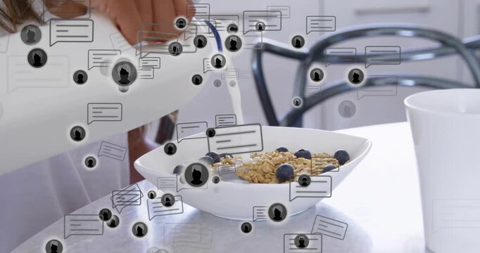Hand entering left pouring milk into granola bowl while chat icons drifting for breakfast prep