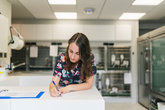 Veterinarian writing notes in veterinary clinic