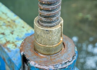 Closeup of a rusty metal screw mechanism with water droplets, detail shot