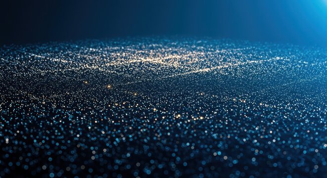Countless shimmering particles form a dynamic undulating surface against a deep blue background