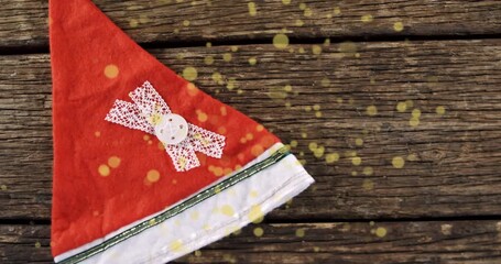 At start red Santa hat sliding upward, rotating on tabletop, sparkles drifting for festive reveal - Powered by Adobe