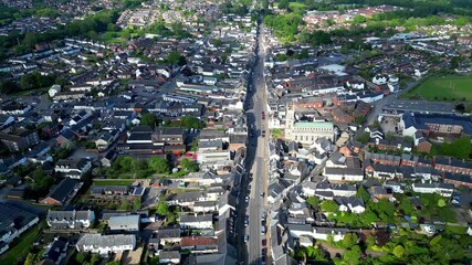 Aerial footage of Honiton High Street in Devon, UK. West facing forward tilt towards St Paul's Church.
