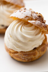 Cream puffs with whipped cream filling on a white plate