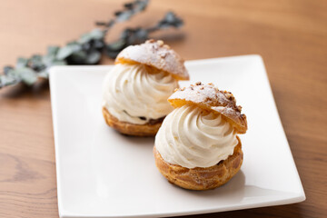 Cream puffs with whipped cream filling on a white plate