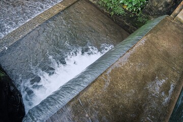 Water flowing through a concrete channel creates a dynamic and textured scene