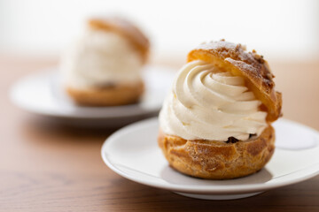 Cream puffs with whipped cream filling on a white plate