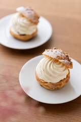 Cream puffs with whipped cream filling on a white plate