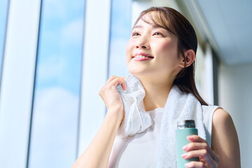 ジムで汗を拭く笑顔の女性