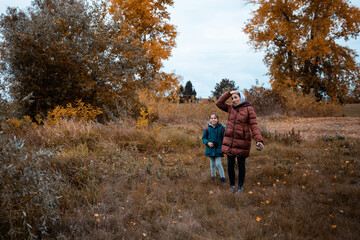 Obraz premium Mother and daughter enjoying autumn walk in nature