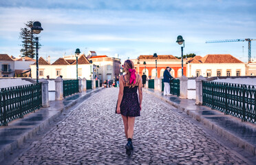 woman exploring cobblestone streets of tavira, algarve, portugal