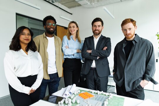 Portrait of smiling team of architectural company looking at camera
