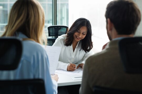Real estate agent signature agreement while couple reading copy of it