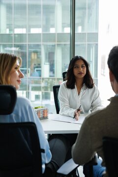 Back cropped view of couple clients discussing with real estate agent