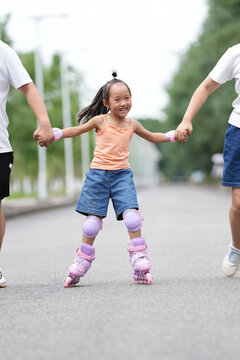 Girl Enjoying Inline Skating With Parents on a Sunny Day