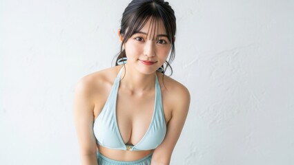 白い壁の前で前かがみになり、優しく微笑む女性