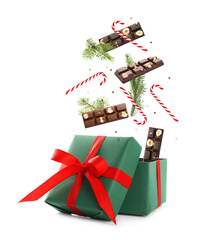 Christmas celebration. Candies falling into gift box on white background