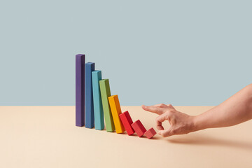 Hand pushes small blocks on descending chart