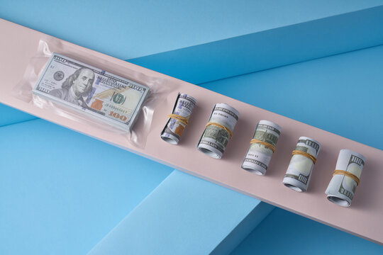 Sealed dollar stack with rolled bills, pastel