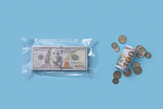 Sealed dollar stack with roll and coin on blue