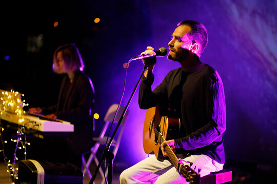 Singing guitarist on night stage