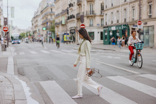 Woman crossing Paris street at crosswalk